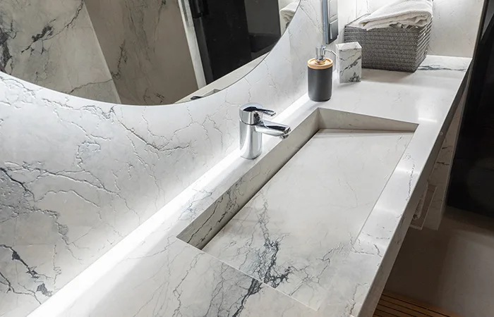 Tasoon saumattomasti upotettu allas korostaa kiven jatkuvuutta ja käsityön laatua.