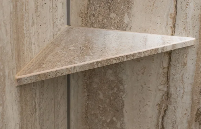 Käsintehdyt hyllyt samasta kivimateriaalista kuin seinät.